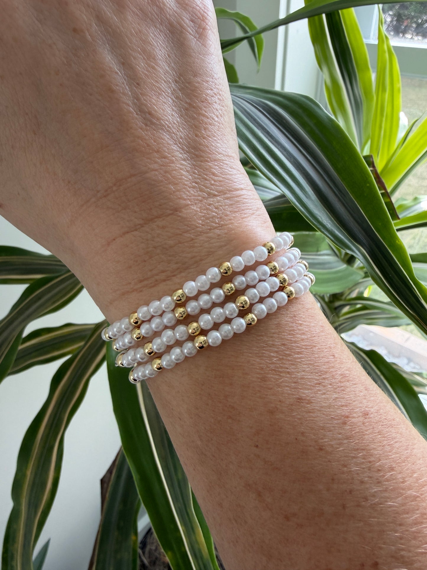 Gold-filled beaded bracelet with pearls stacked with minimalist gold jewelry