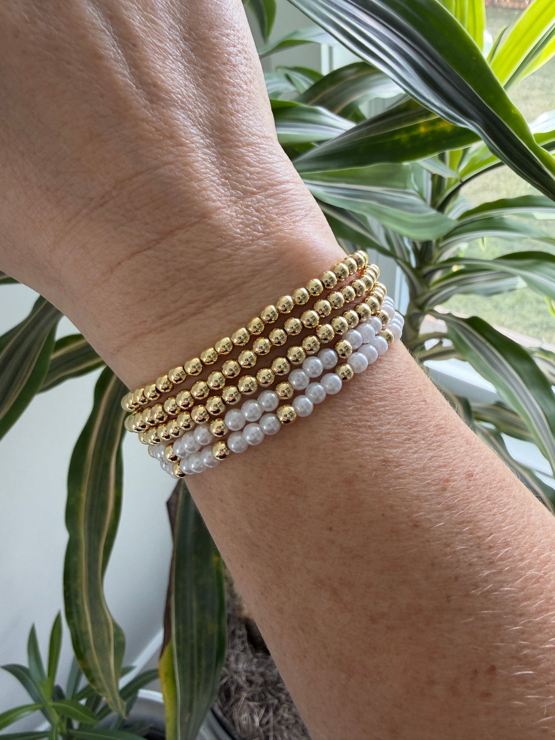 Gold-filled beaded bracelet with pearls stacked with minimalist gold jewelry
