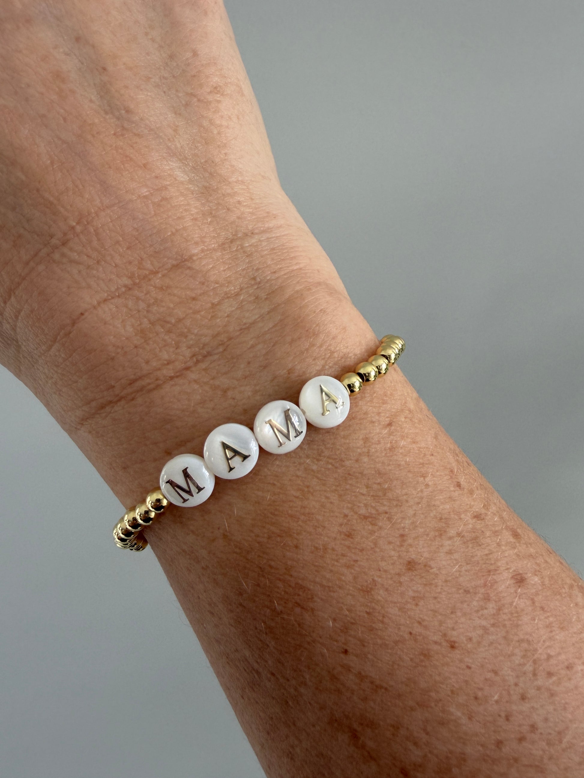 Gold-filled mama bracelet stacked with minimalist gold bracelets