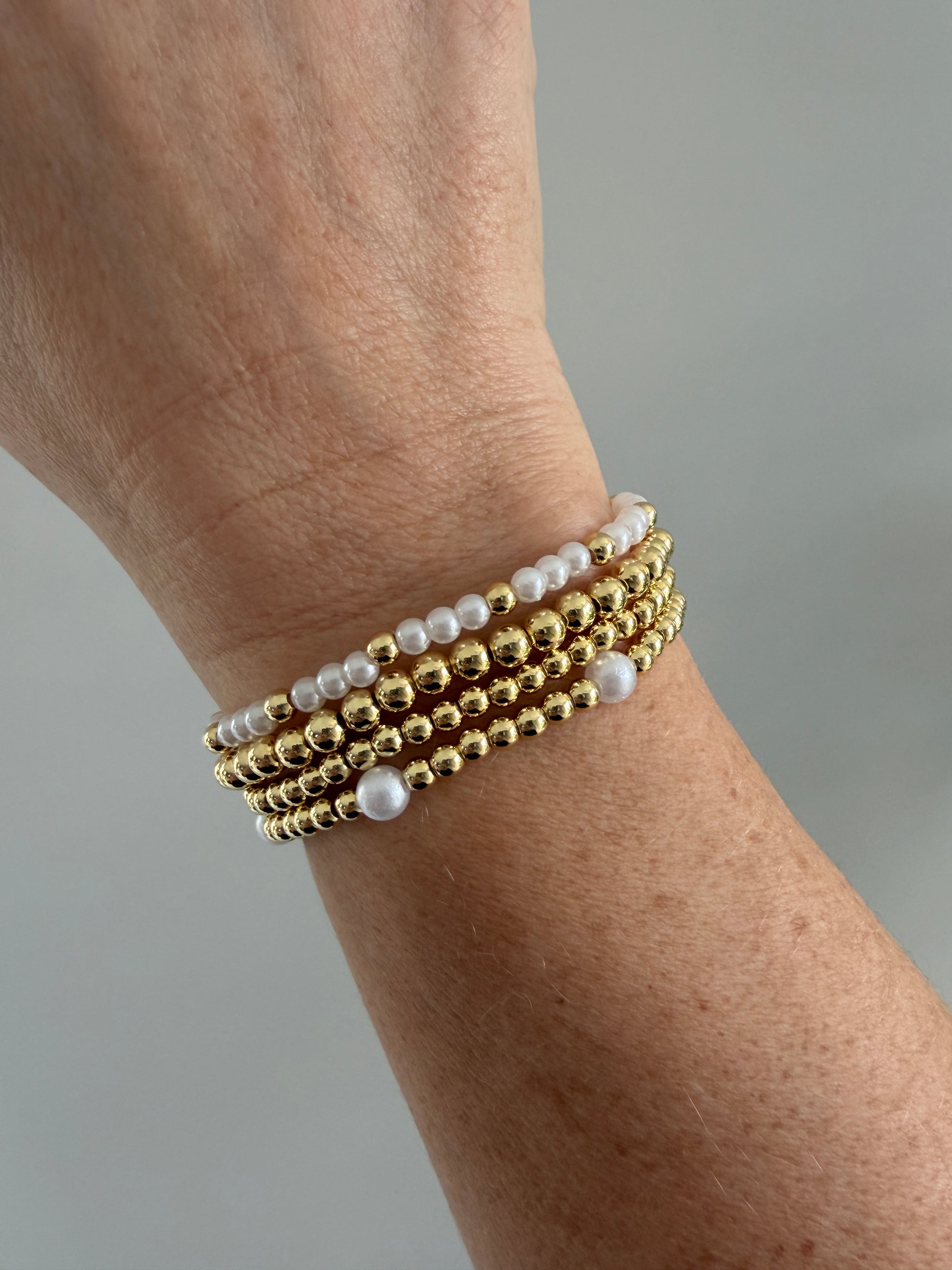 Polished 4mm gold-filled beads paired with pearls on a stretch bracelet