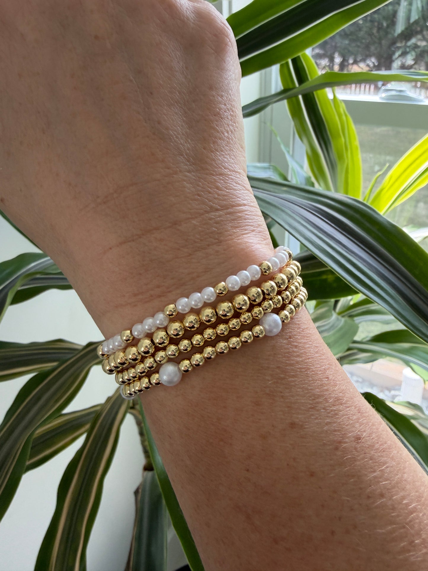 Polished 4mm gold-filled beads paired with pearls on a stretch bracelet