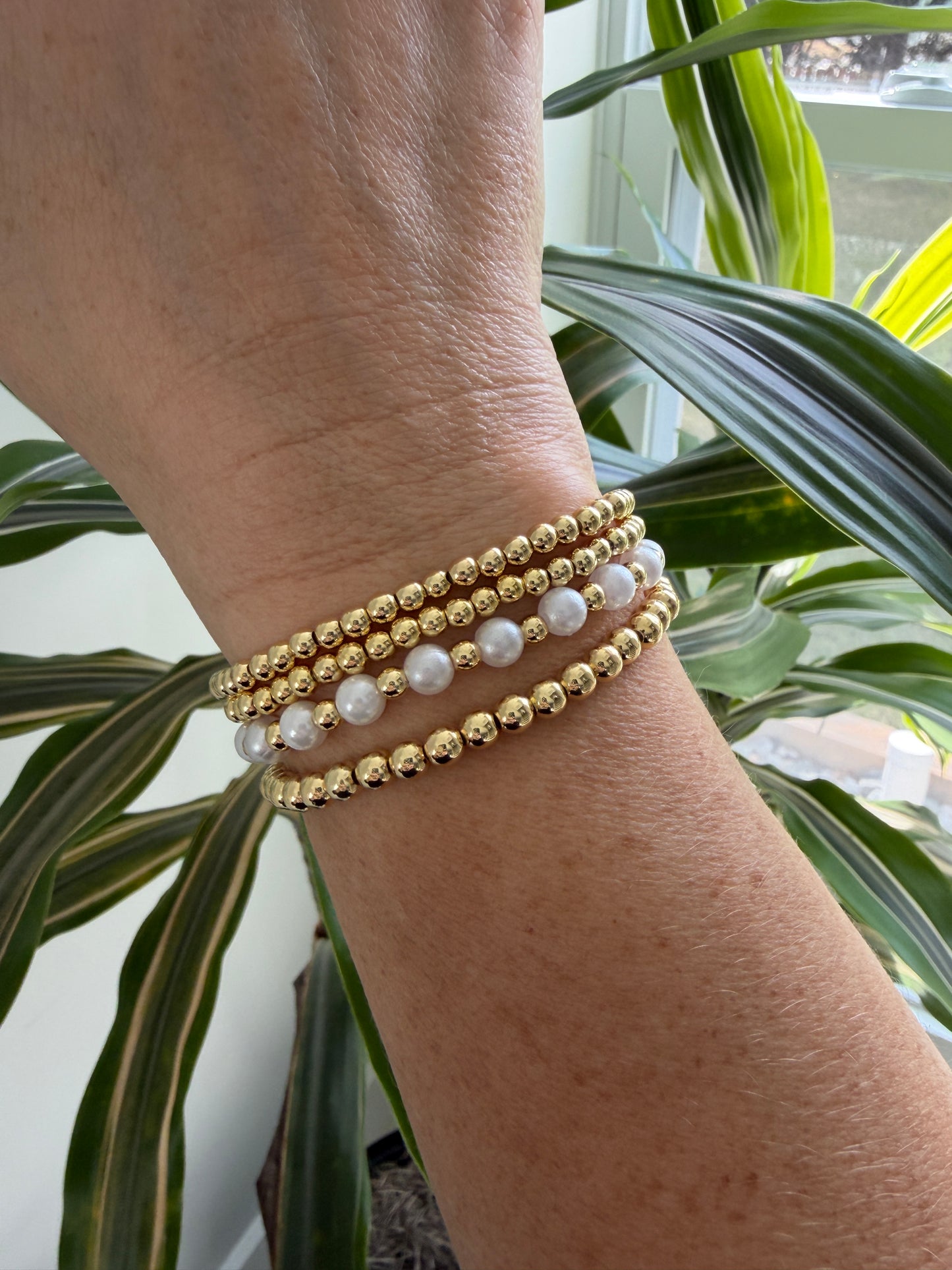 Gold-filled beaded bracelet with pearls stacked with minimalist gold jewelry
