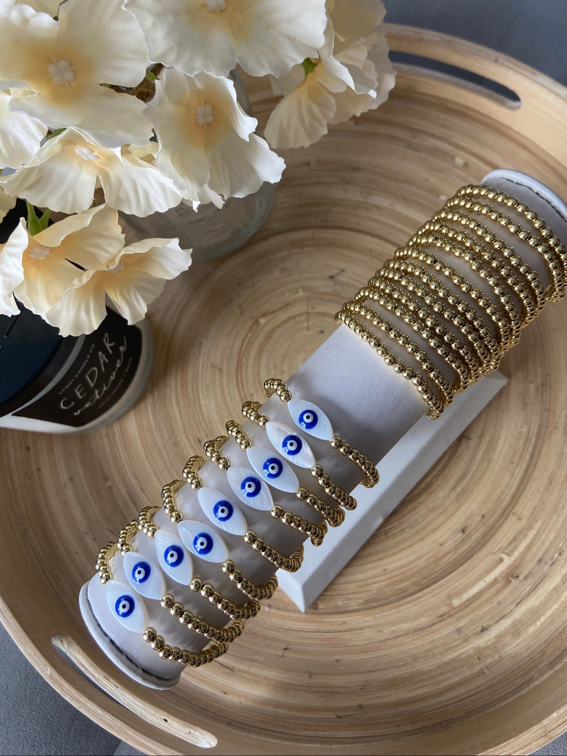 Gold-filled evil eye bracelet stacked with minimalist gold bracelets